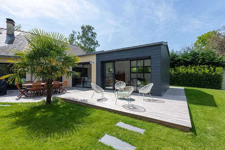 La terrasse en périphérie de l'extension de maison.