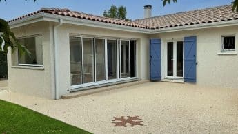 Une extension de maison en tuiles, ouverte sur les espaces extérieurs et sur une belle terrasse.