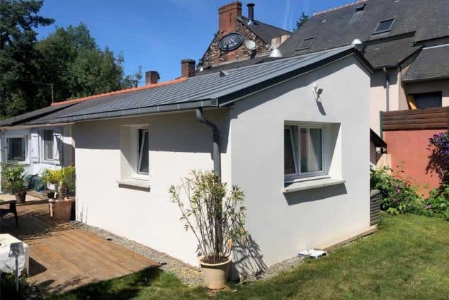 Une extension de maison avec une toiture à deux pentes.