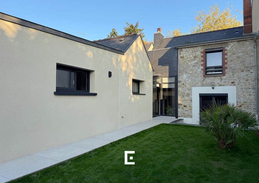Ensemble architectural harmonieux entre la maison des années 50 et la nouvelle extension, assurant une continuité esthétique et fonctionnelle.