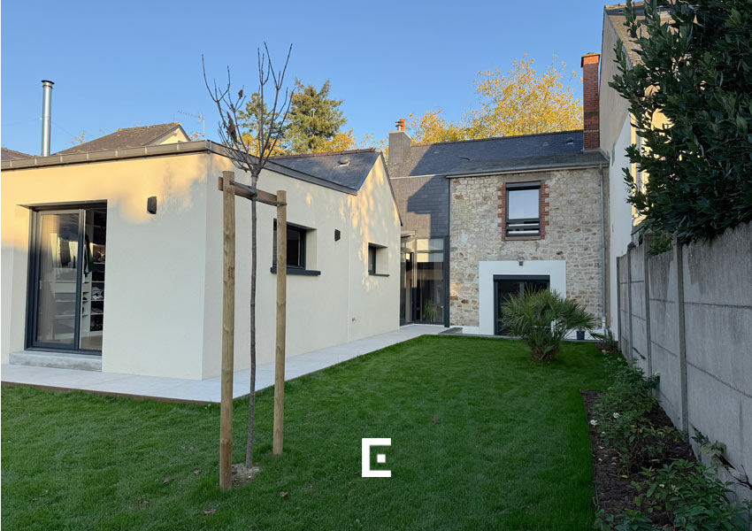 Maison avec extension moderne accolée à une partie ancienne en pierre, vue depuis le jardin