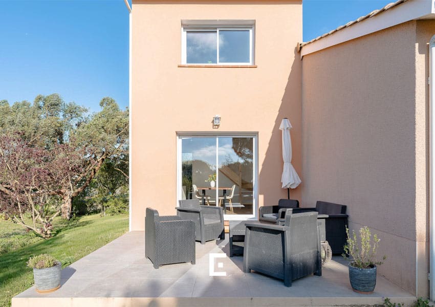 Un coin terrasse prolonge l’extension de la maison et offre un espace agréable pour profiter de la vue et de la lumière naturelle.