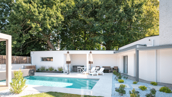 Piscine moderne avec terrasse, mobilier de jardin, parasols et jardin paysager avec gravier blanc et végétation.
