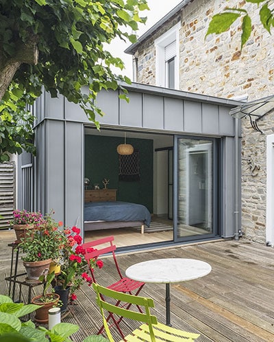 Un agrandissement à toit plat pour agrandir cette maison ancienne.
