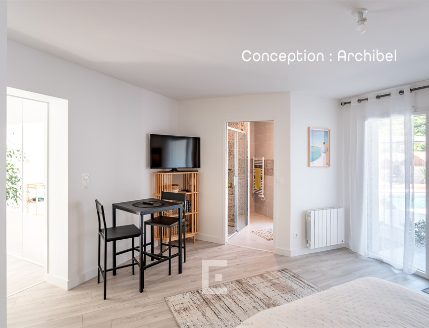 Suite parentale lumineuse avec de grandes ouvertures laissant entrer la lumière naturelle, offrant un espace confortable et apaisant.