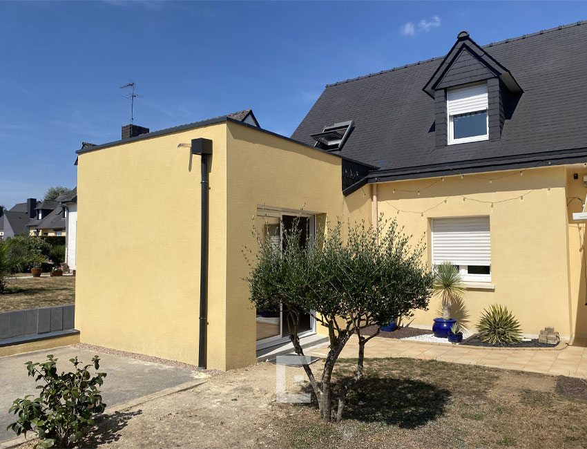Maison avec façade jaune et toiture noire